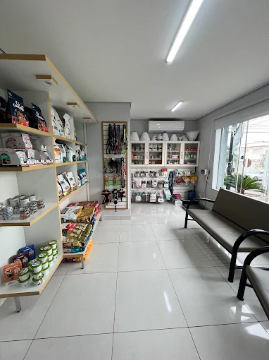 Recepção da clínica com área de espera e prateleiras de produtos veterinários.